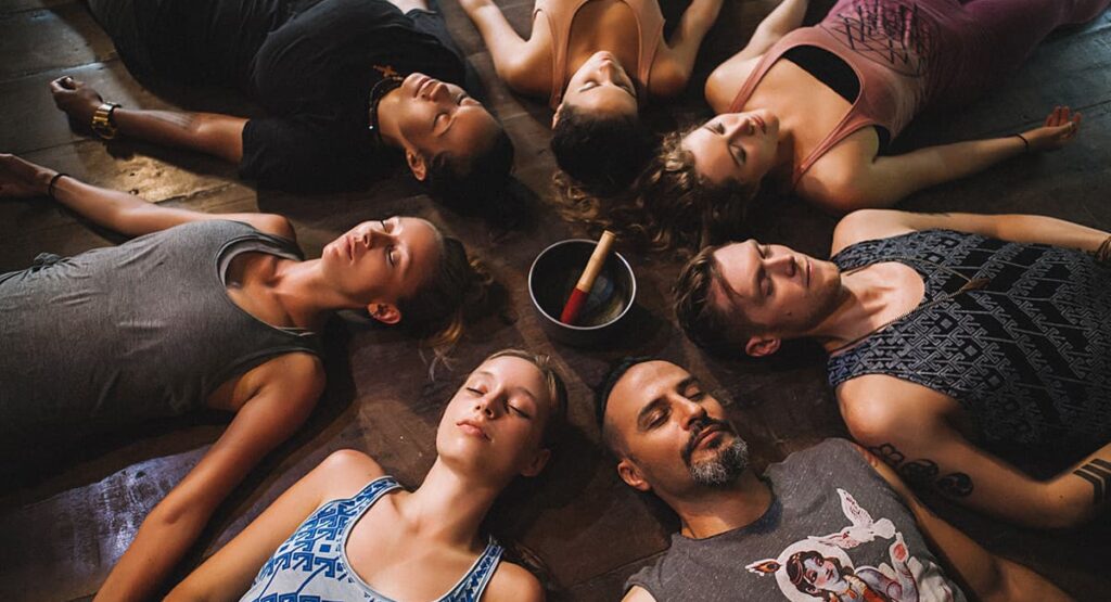 Practitioners lying down in circle for workshop and retreat in Bali